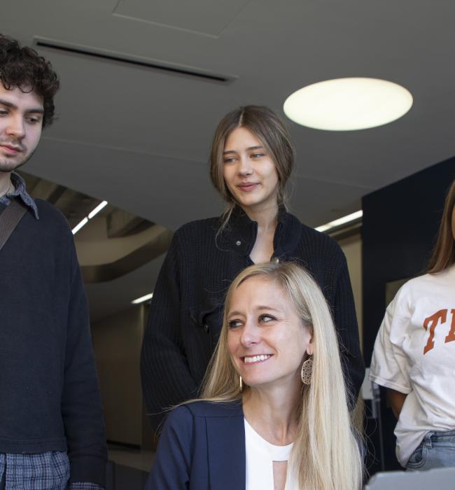 students and professor around a computer